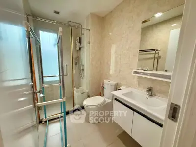 Modern bathroom with glass shower and sleek vanity in a contemporary home.