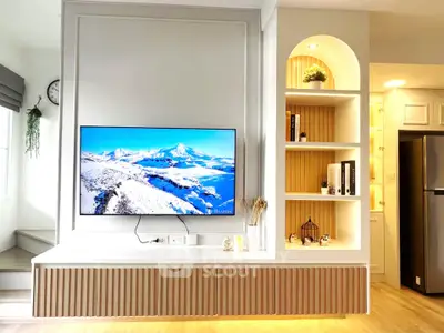Modern living room with wall-mounted TV and stylish shelving, featuring sleek design and cozy ambiance.