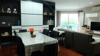 Modern living room with dining area and balcony view, featuring stylish furniture and decor.