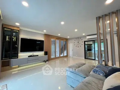 Spacious modern living room with sleek design and large TV, perfect for relaxation and entertainment.