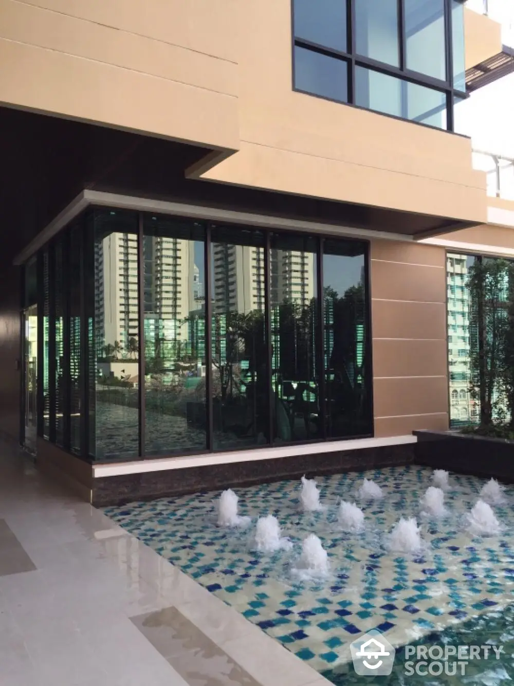 Luxurious modern building with elegant water feature and cityscape view.