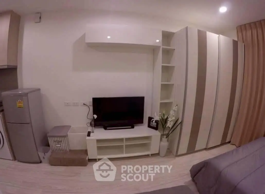 Modern living room with sleek storage and entertainment center in stylish apartment.