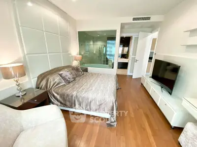 Luxurious bedroom with modern decor and ensuite bathroom in upscale apartment