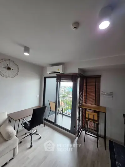 Modern living room with balcony view, featuring sleek furniture and natural light.