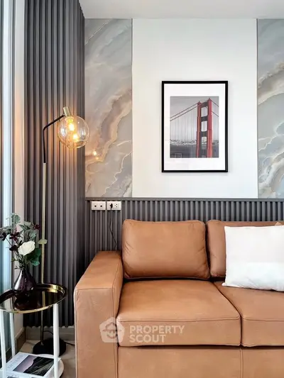 Stylish living room with modern decor and leather sofa, featuring elegant wall art and ambient lighting.