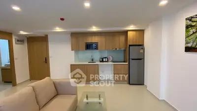 Modern living room with open kitchen and sleek appliances in a stylish apartment.