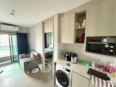 Modern studio apartment with open kitchen and cozy living area, featuring a balcony with city view.