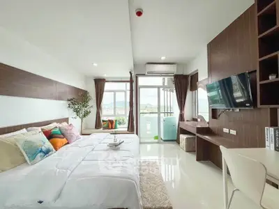 Modern bedroom with balcony and scenic view, featuring stylish decor and ample natural light.