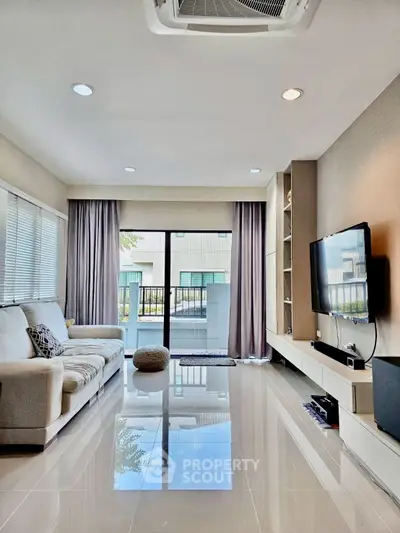 Modern living room with sleek design, large windows, and wall-mounted TV for ultimate comfort and style.