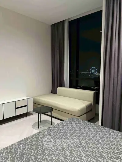 Modern bedroom with night view, featuring sleek furniture and large window overlooking city lights.