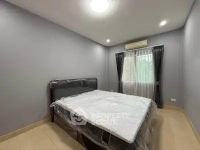 Modern bedroom with large bed and natural light from window