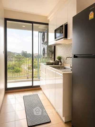 Modern kitchen with balcony view, sleek appliances, and ample natural light.