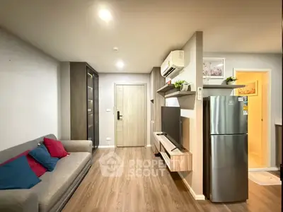 Modern living room with stylish decor and sleek appliances in a cozy apartment setting.