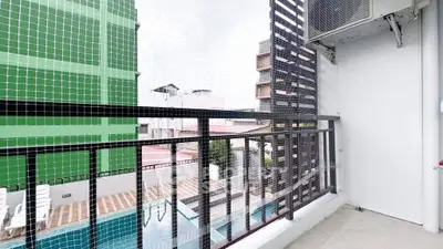 Modern balcony with pool view and safety netting in urban setting