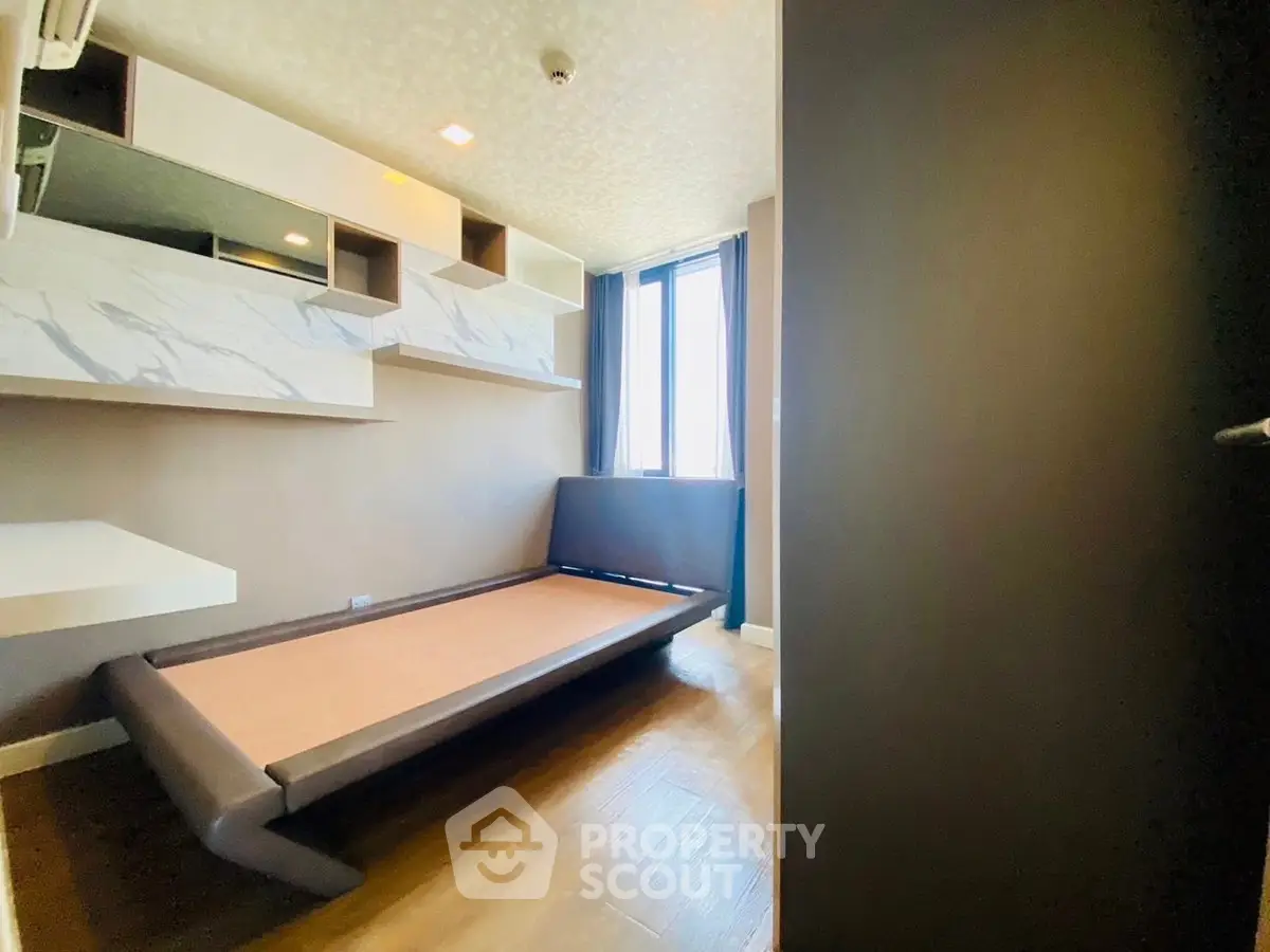 Modern minimalist bedroom with sleek bed and large window