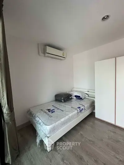 Cozy bedroom with air conditioning and modern furnishings, perfect for comfortable living.
