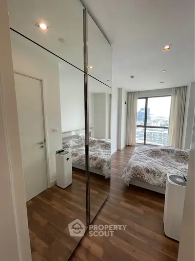 Modern bedroom with mirrored closet and city view