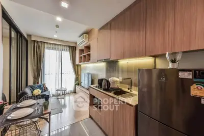 Modern kitchen with open layout and cozy living area, featuring sleek appliances and stylish decor.