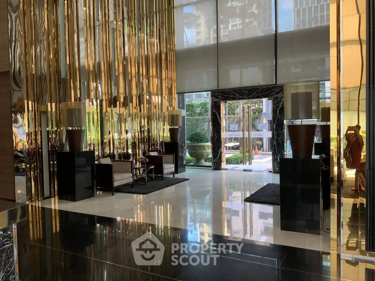 Luxurious building entrance with modern decor and reflective surfaces