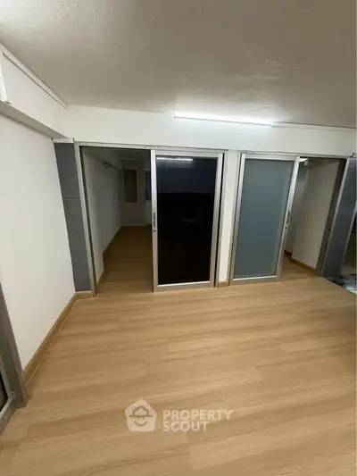 Spacious room with sliding glass doors and wooden flooring, ideal for versatile use.