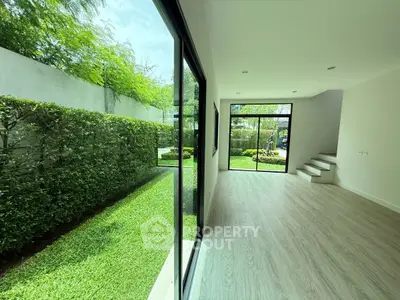 Spacious modern living room with large windows overlooking lush garden