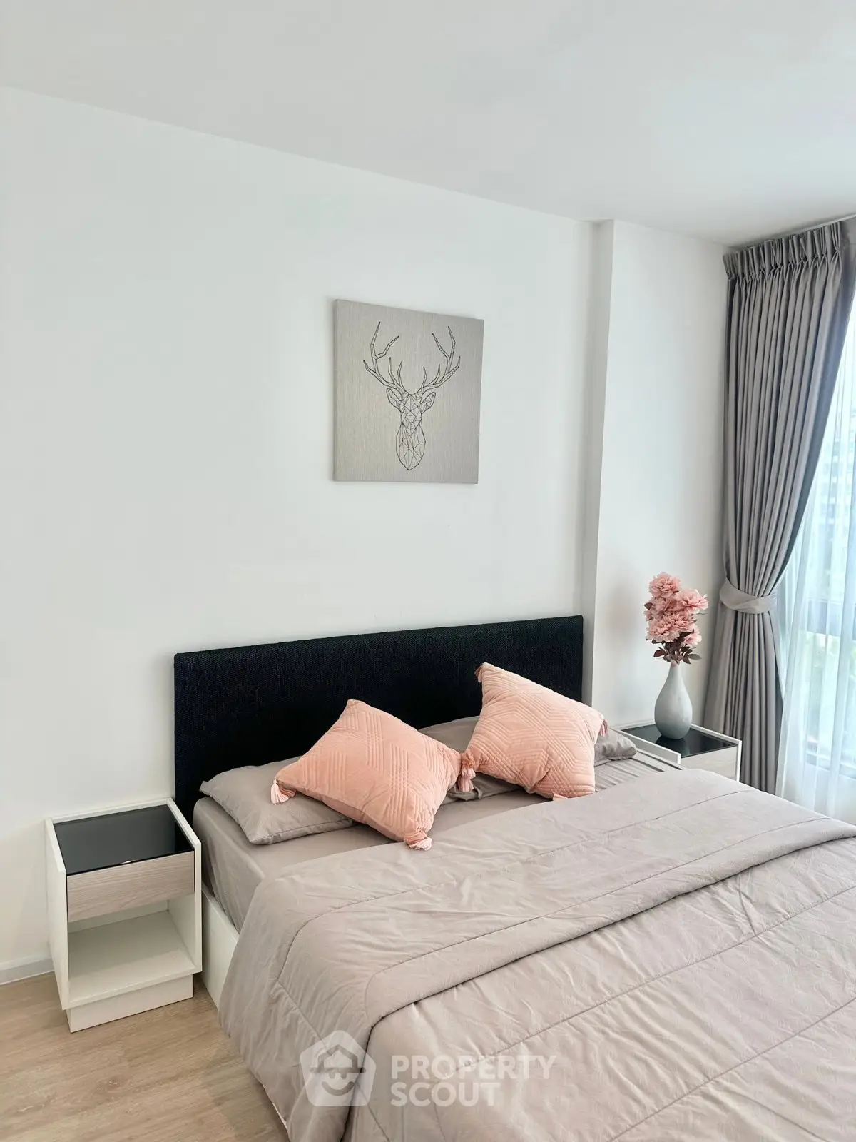 Modern bedroom with stylish decor and natural light, featuring a comfortable bed and elegant curtains.