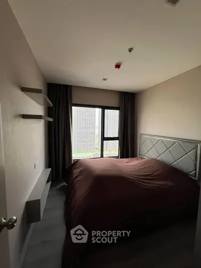 Cozy bedroom with large window and modern decor in urban apartment