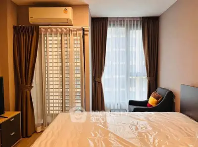 Cozy bedroom with large windows and modern furnishings in a stylish apartment.