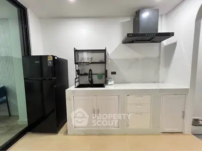 Modern kitchen with sleek black fridge and stylish range hood