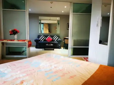 Spacious bedroom with modern decor and cozy seating area in a stylish apartment.