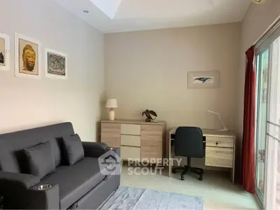 Modern living room with stylish furniture and natural light, perfect for relaxation and work-from-home setup.