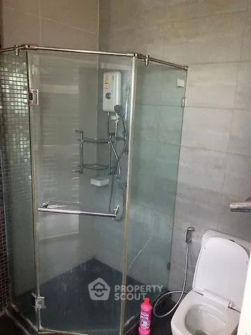 Modern bathroom with glass shower enclosure and sleek tile design.