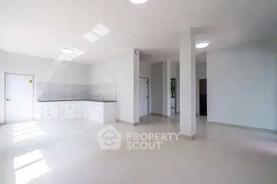 Spacious open-plan living area with modern kitchen and ample natural light.