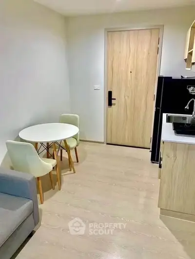 Modern compact living room with dining area and kitchenette in stylish apartment.