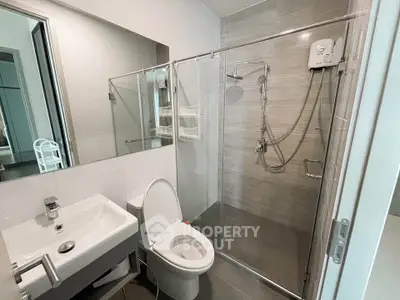 Modern bathroom with glass shower enclosure and sleek fixtures