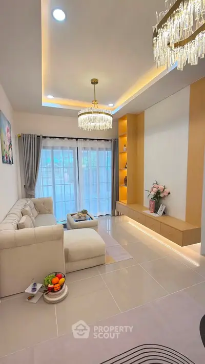 Elegant living room with modern chandelier and cozy seating area, perfect for relaxation and entertainment.