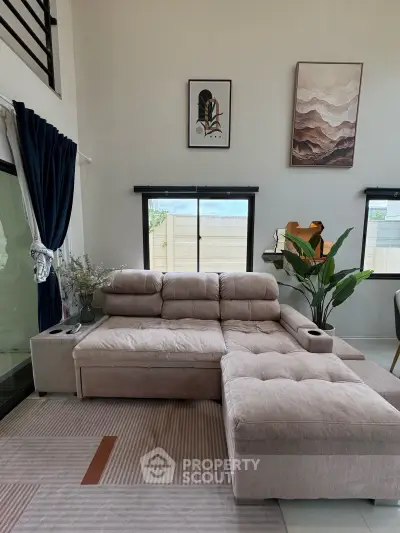 Spacious living room with modern sectional sofa and stylish decor, perfect for relaxation and entertaining.