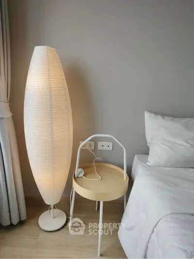 Modern bedroom with stylish floor lamp and cozy bedding