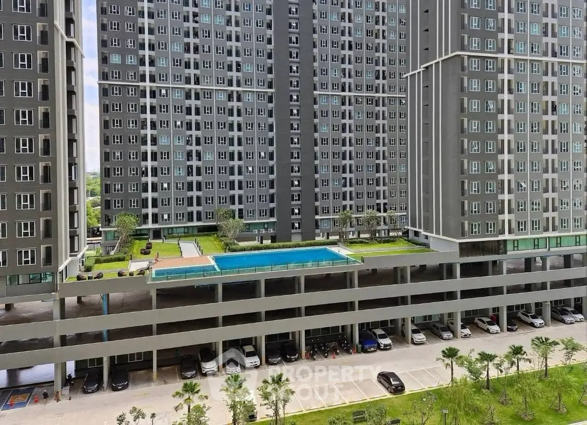 Modern high-rise building with elevated pool and parking, showcasing urban living amenities.