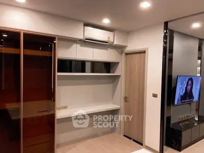 Modern bedroom with built-in shelves and air conditioning, featuring a sleek design and warm lighting.