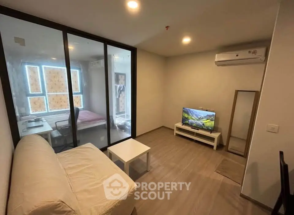Modern living room with glass partition and cozy furniture in a stylish apartment.
