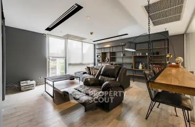 Modern living room with sleek furniture and large windows offering natural light.