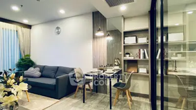 Modern living room with dining area, featuring sleek furniture and stylish decor in a cozy apartment setting.