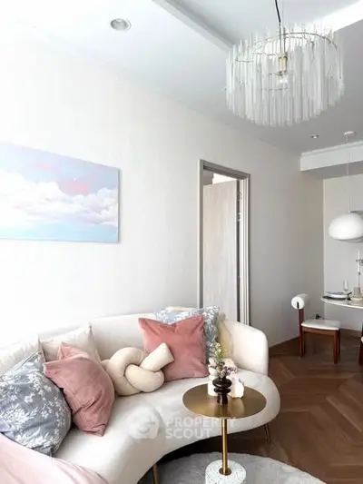 Elegant living room with modern decor and stylish lighting, featuring a cozy curved sofa and chic coffee table.