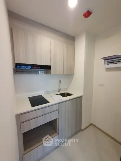 Modern compact kitchen with sleek cabinetry and electric stove