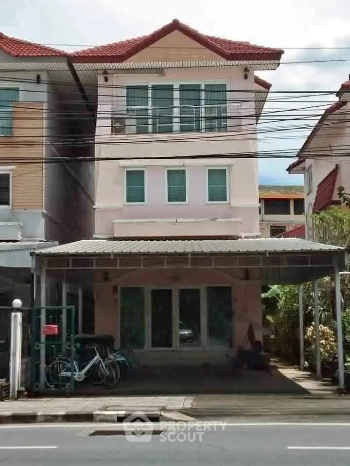 Charming three-story townhouse with covered parking and bicycles, ideal for urban living.