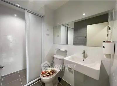 Modern bathroom with sleek fixtures and spacious shower in contemporary apartment.