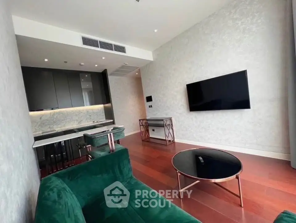 Luxurious modern living room with elegant green velvet sofa and sleek open kitchen design.