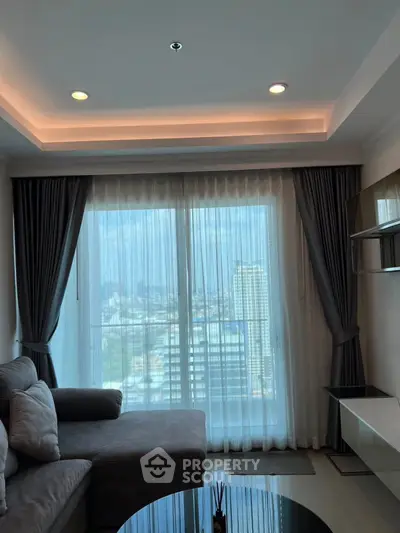 Modern living room with city view, featuring elegant curtains and cozy seating.