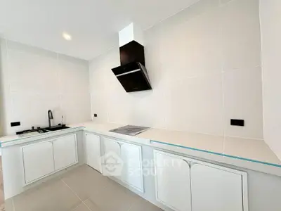 Modern kitchen with sleek white cabinetry and built-in appliances in a contemporary home.